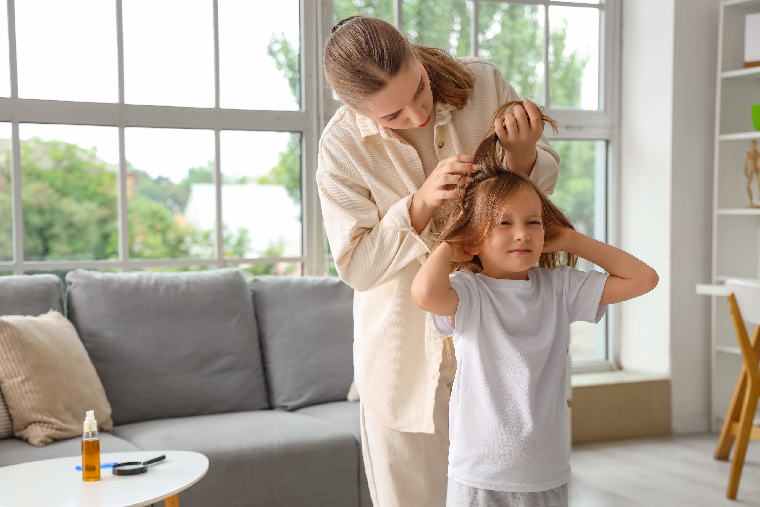 Parent checking a child hair as part of year-round lice prevention