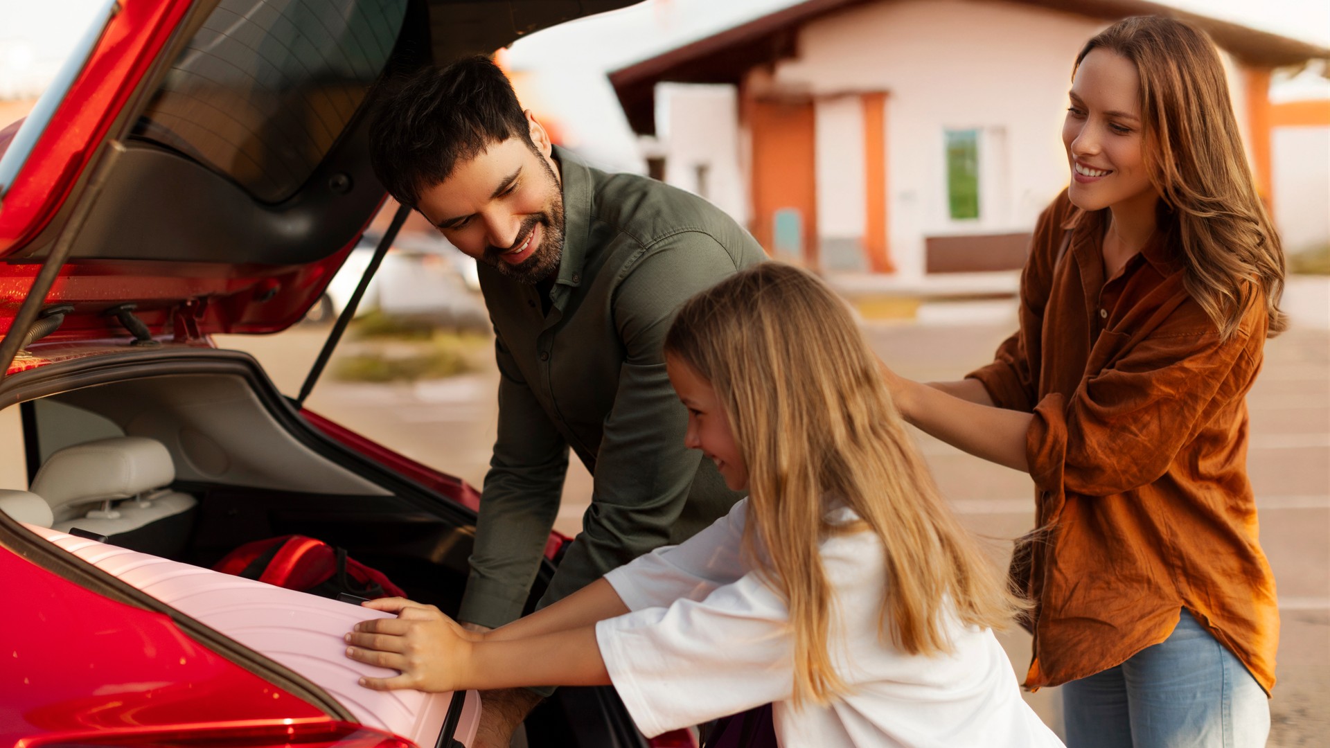 Family loading luggage into a car for spring break travel