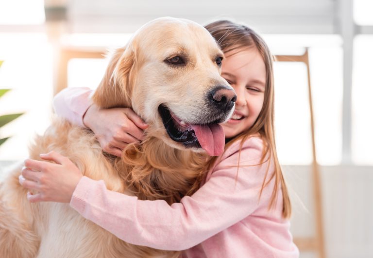 Smiling child hugging a dog