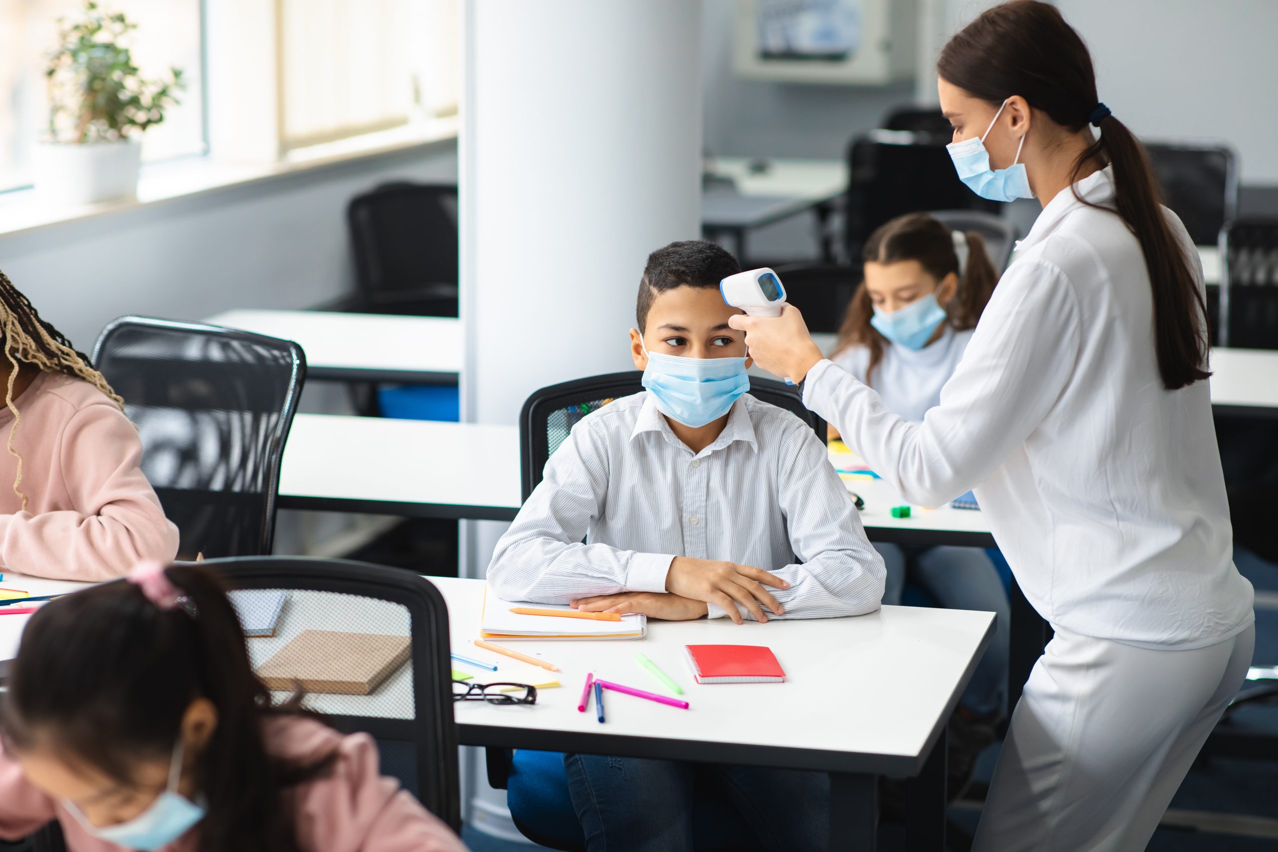 Teacher checking a student during a school health screening